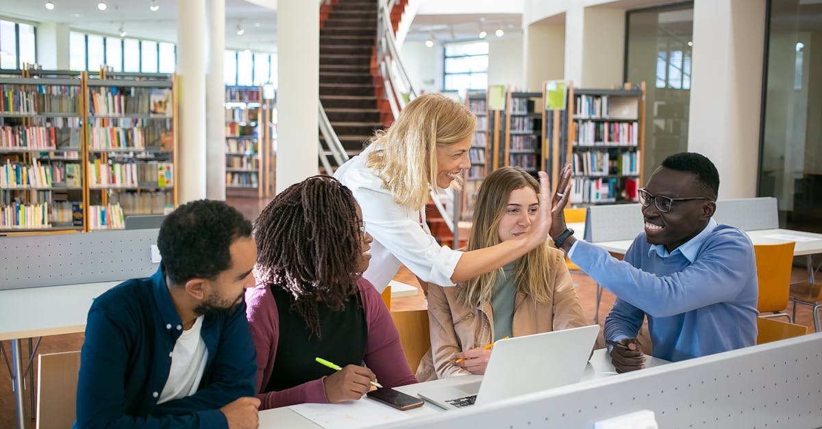 A group of multiethnic college students collaborating on a project in a modern library setting.